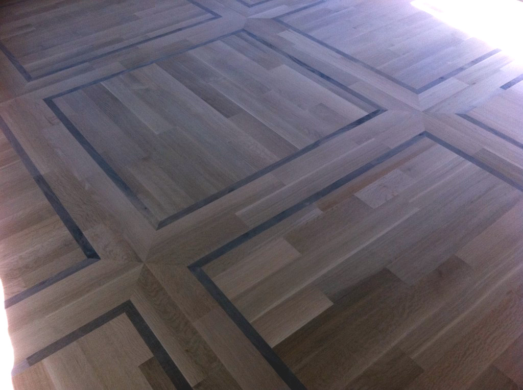 Site finished, engineered, quarter sawn white oak with walnut highlights.